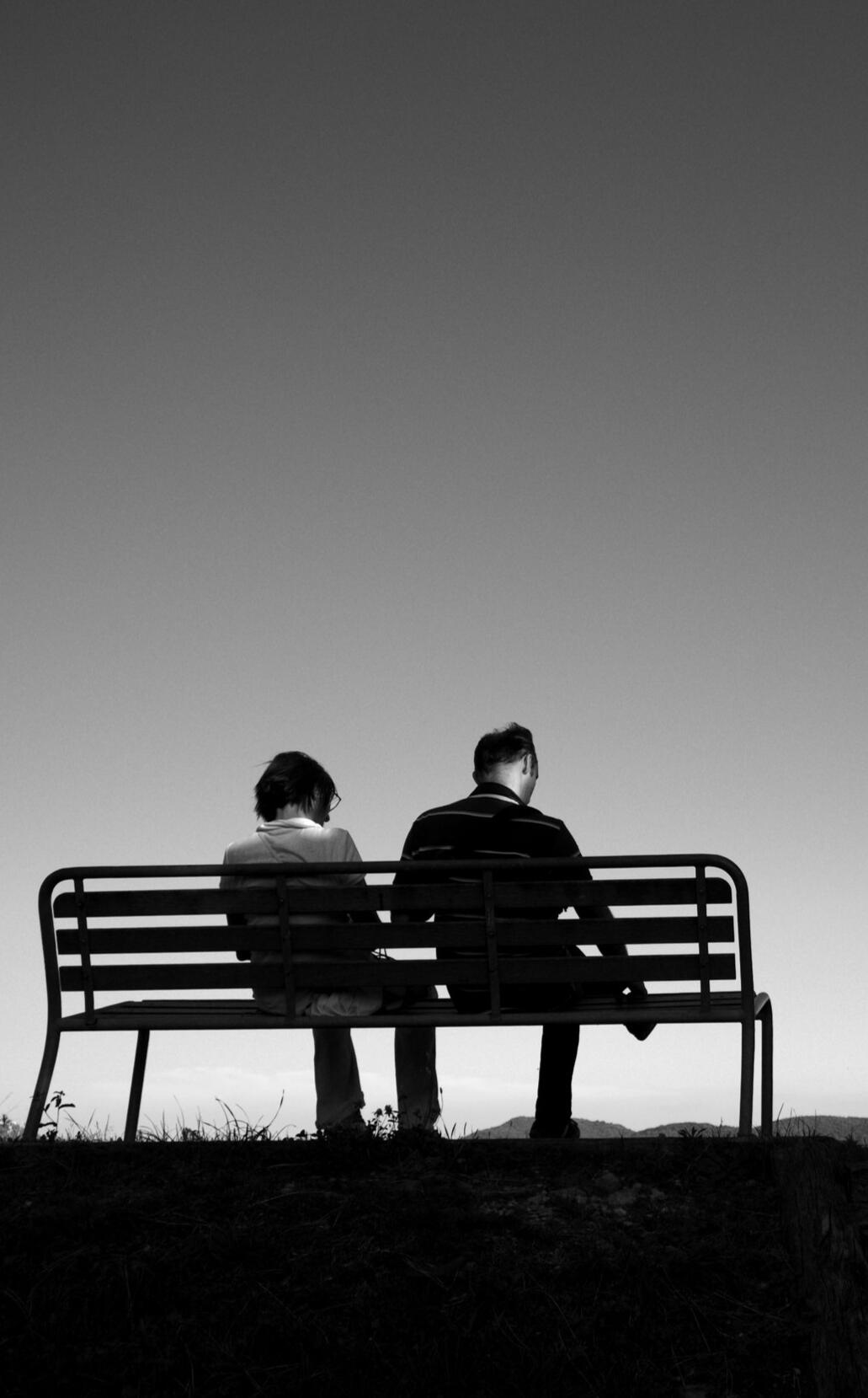 Couple sitting in silence on a bench, symbolizing emotional disconnection and the need for marriage counseling or relationship therapy in Murfreesboro.